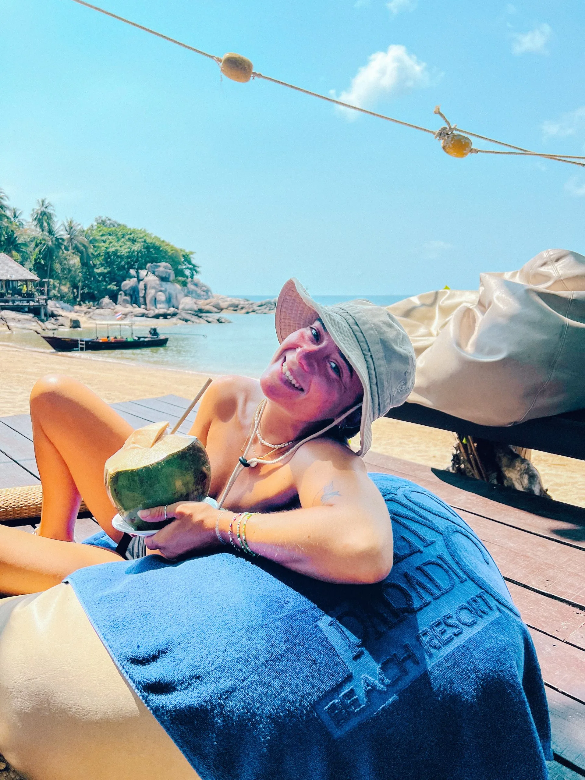 Girl on a beach drinking coconut